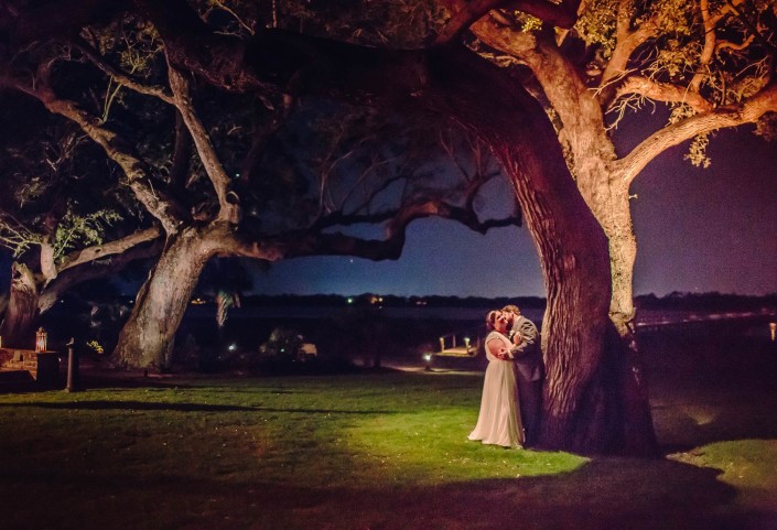 Bride and Groom Kissing Under the Tree