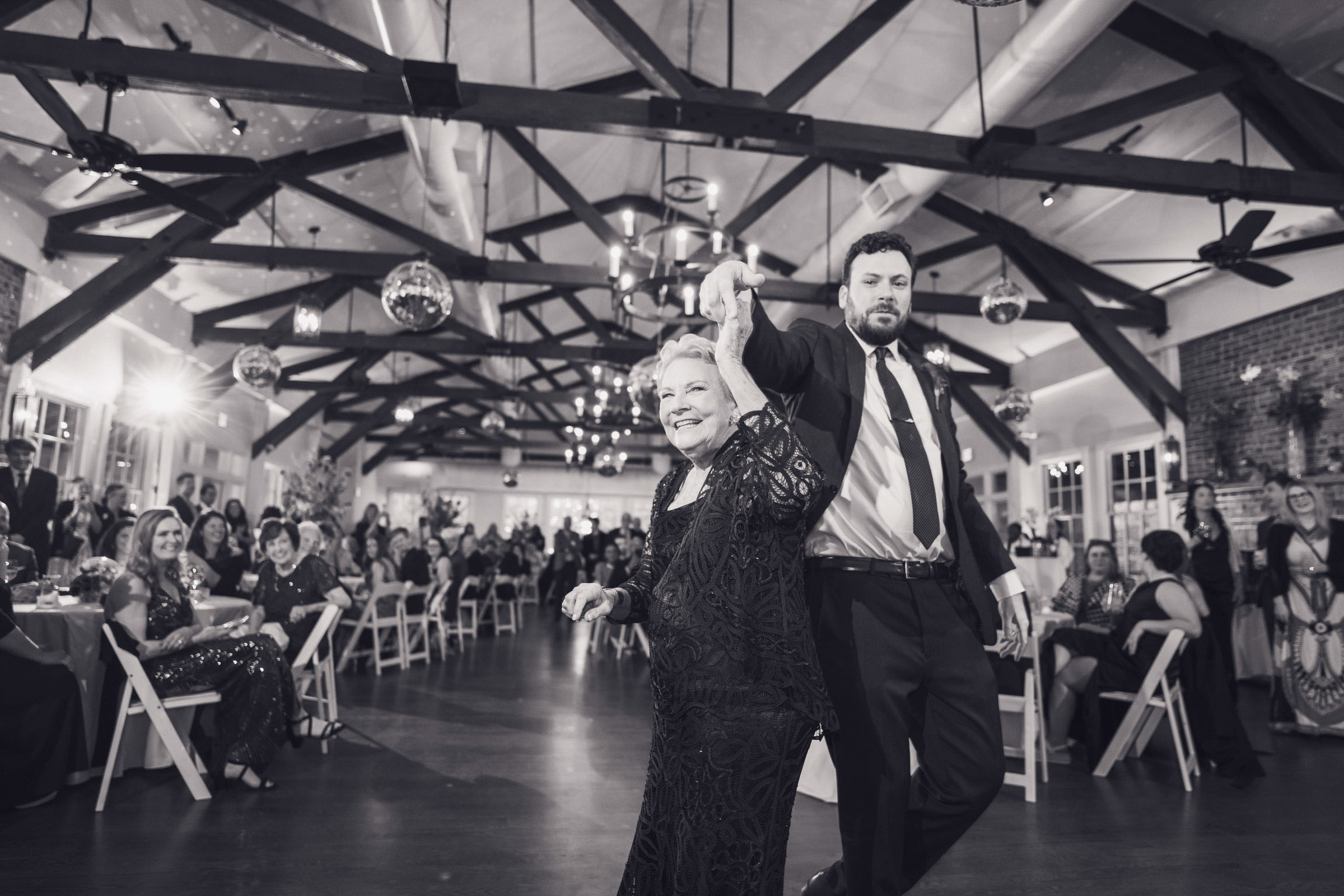 Groom and his Mom dancing during reception with guests watching at Alhambra Hall Charleston