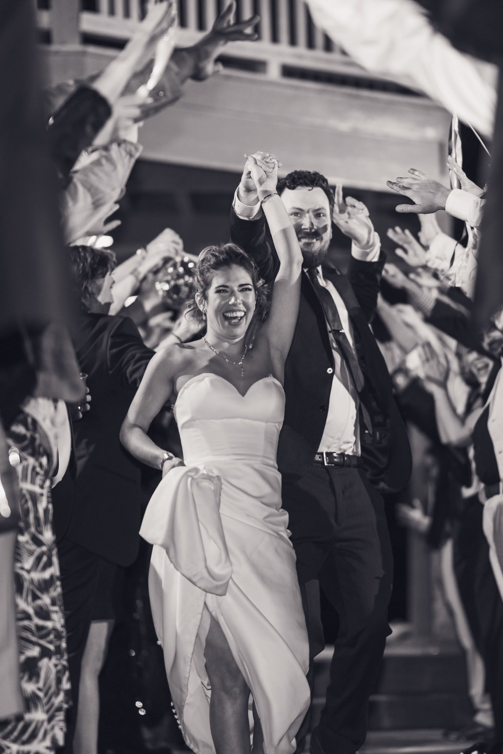 Bride and groom celebrating during grand departure with guests cheering at Alhambra Hall Charleston