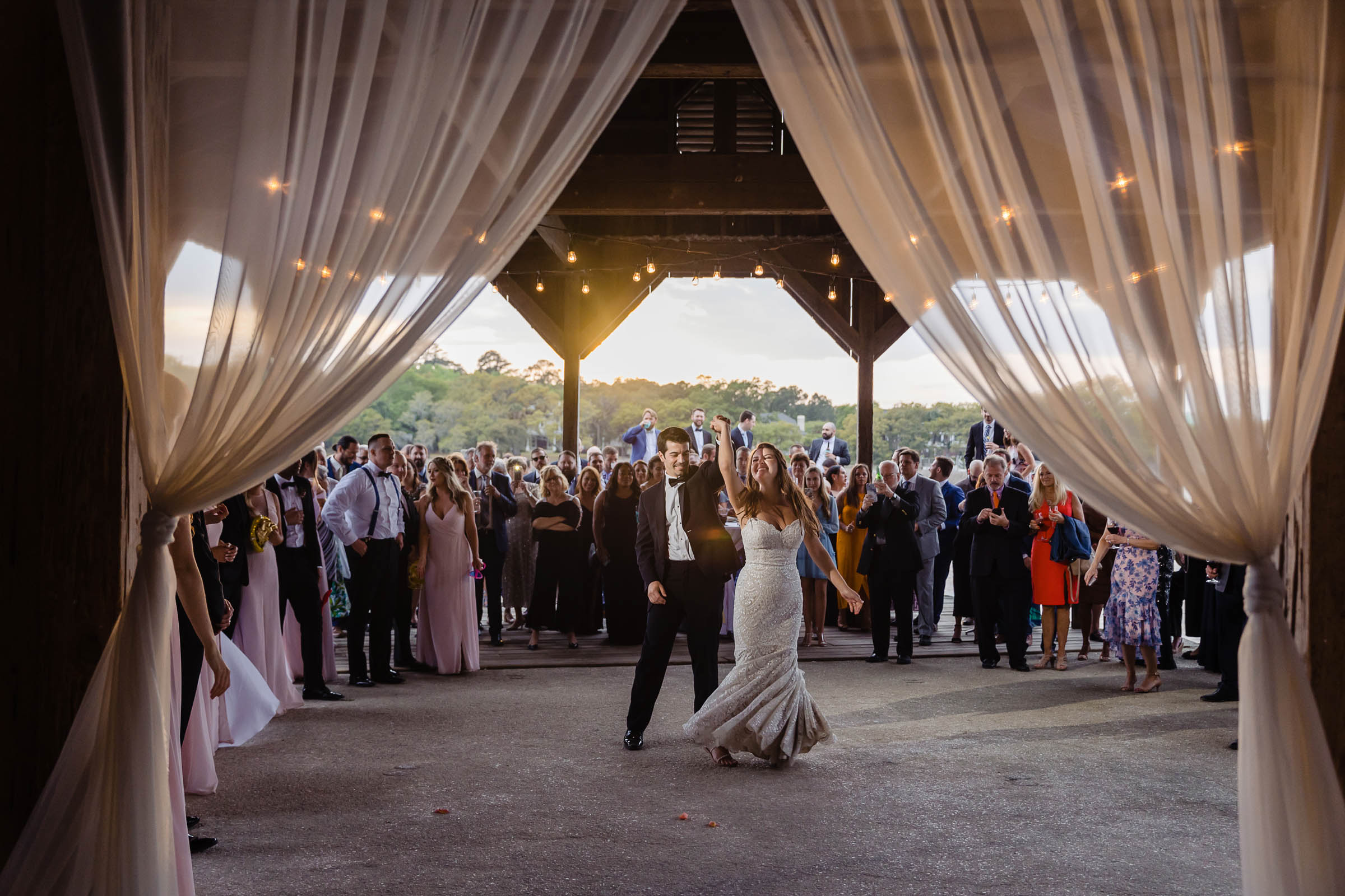 Cotton Dock First Dance Newlyweds dancing into their reception as guests gather beneath the Cotton Dock at Boone Hall