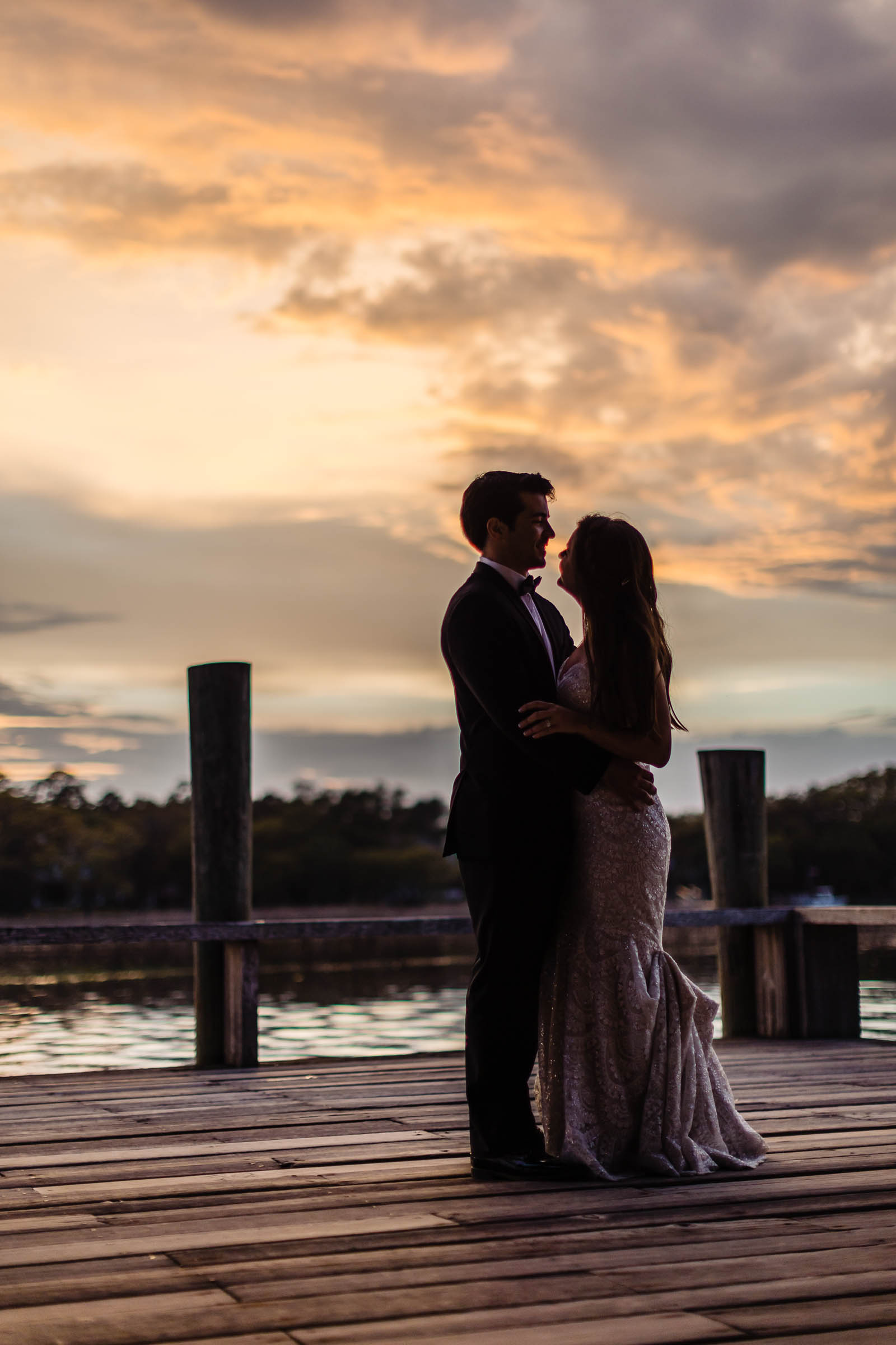 Boone Hall Sunset Dock Portrait Bride and groom silhouetted together on the dock beneath a dramatic Charleston sunset