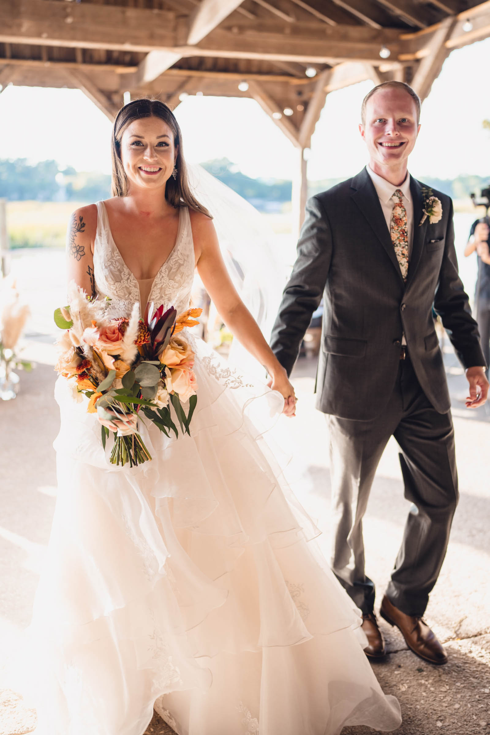 Boone Hall Newlyweds Newly married couple walking hand in hand beneath the waterfront pavilion at Boone Hall Plantation