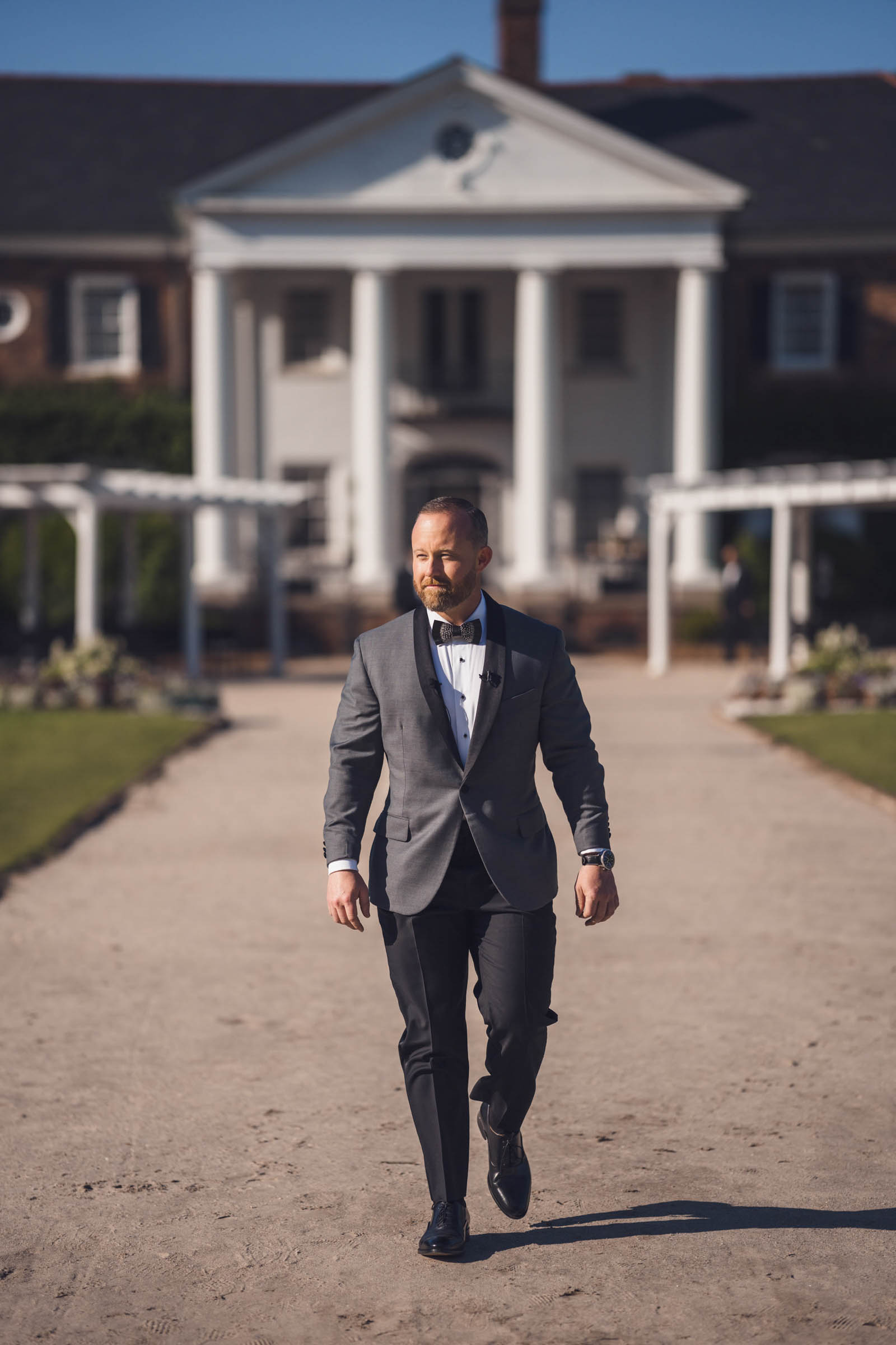 Boone Hall Groom Portrait Groom walking along the main drive with the Boone Hall mansion behind him