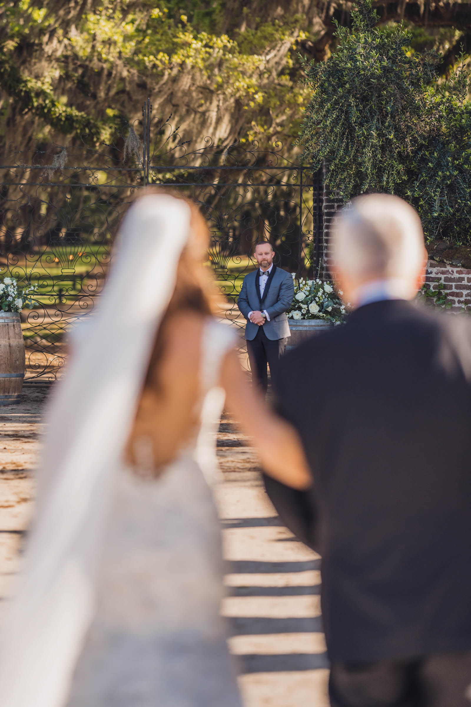 Boone Hall Wedding First Look Groom watching as the bride approaches with her father before their Boone Hall wedding ceremony