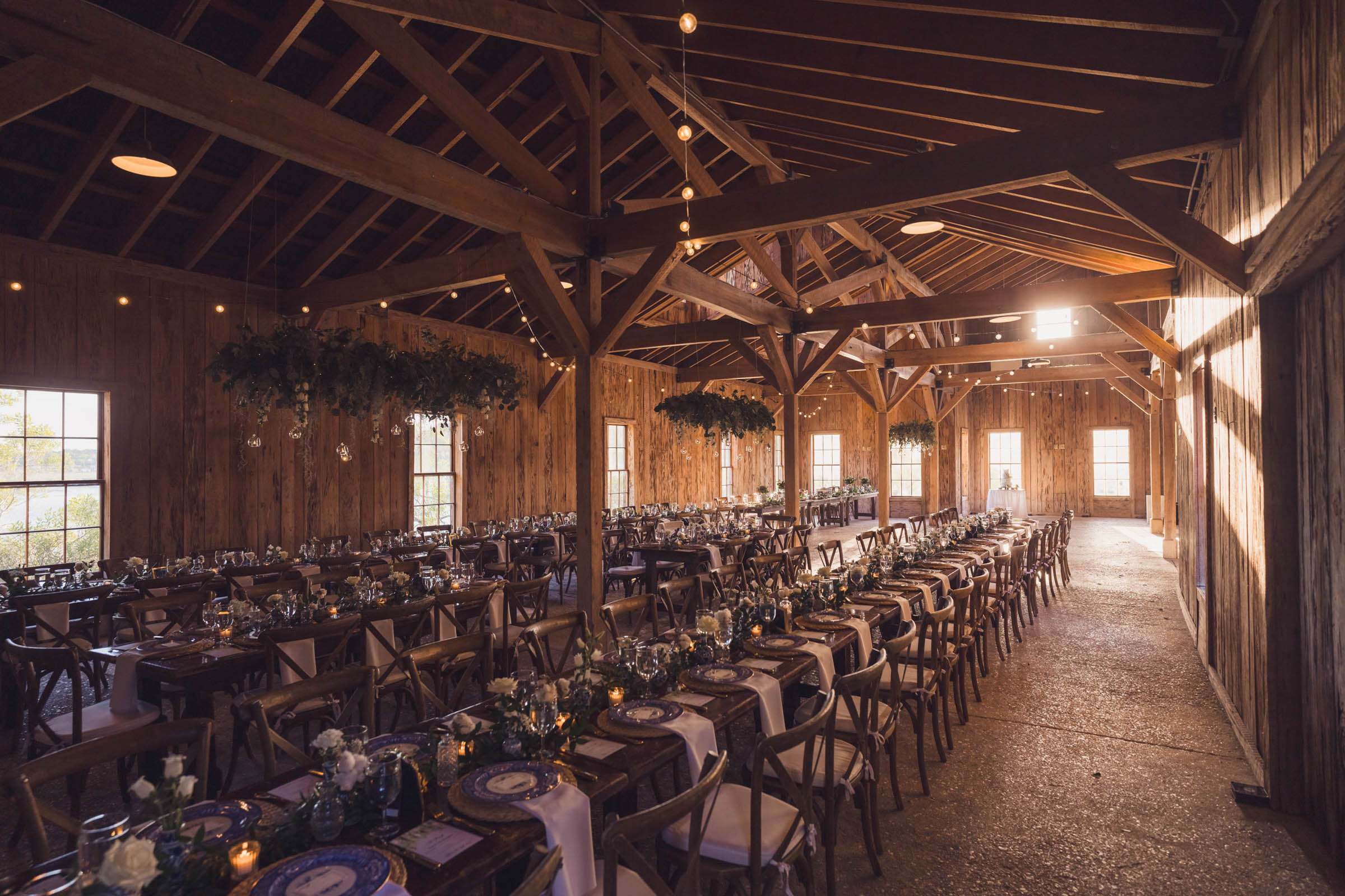 Boone Hall Cotton Dock Reception Setup Long reception tables set for dinner inside the rustic Cotton Dock at Boone Hall Plantation