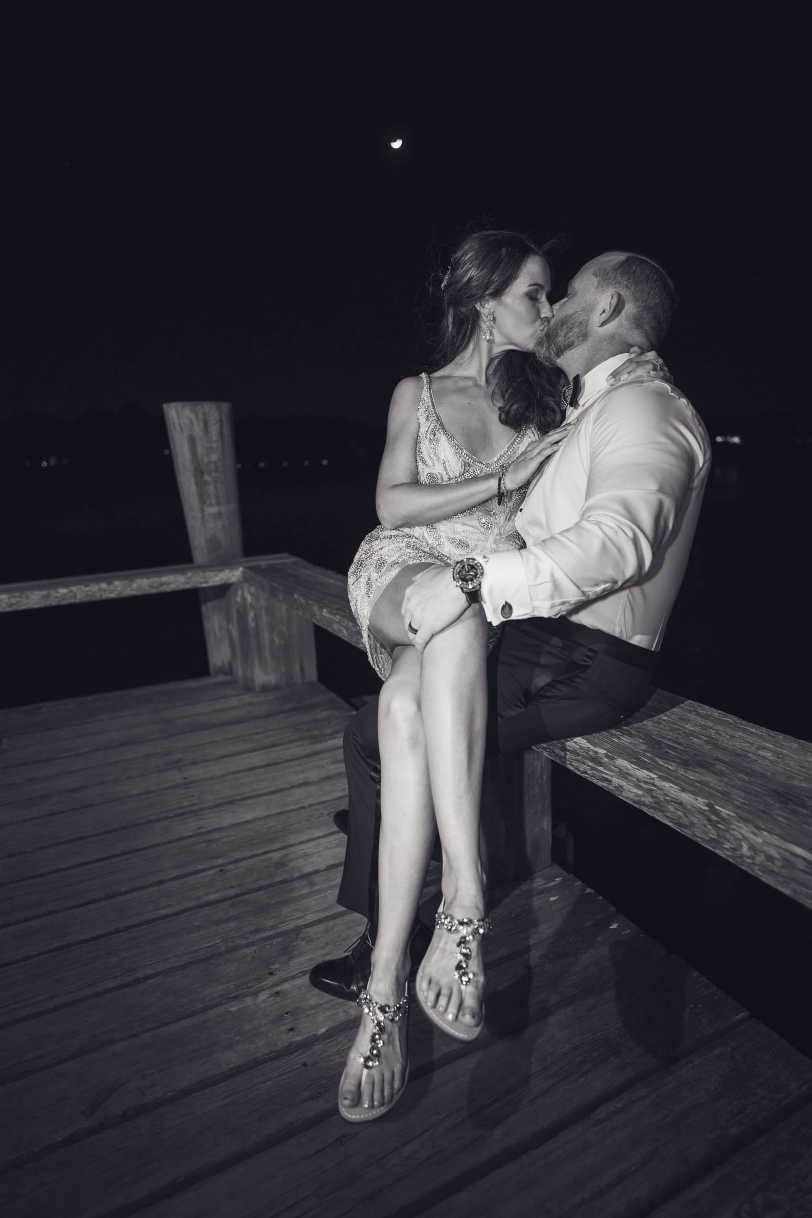 Boone Hall Moonlight Wedding Portrait Newlyweds kissing on the waterfront dock at Boone Hall beneath a crescent moon