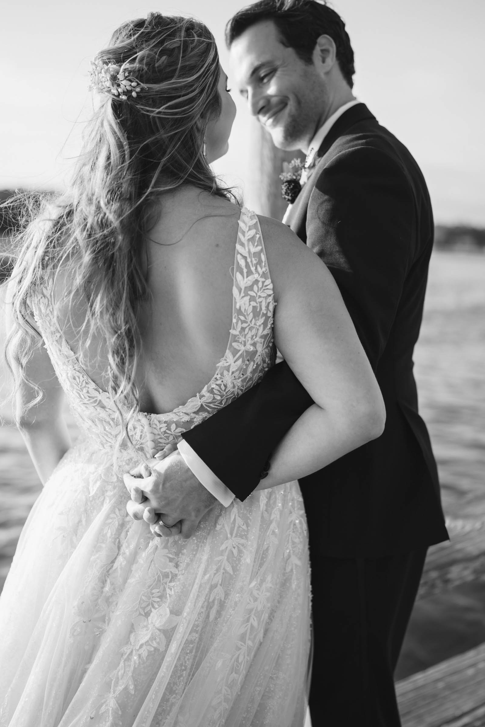 Boone Hall Dock Wedding Portrait Black-and-white portrait of newlyweds holding hands together beside the water at Boone Hall