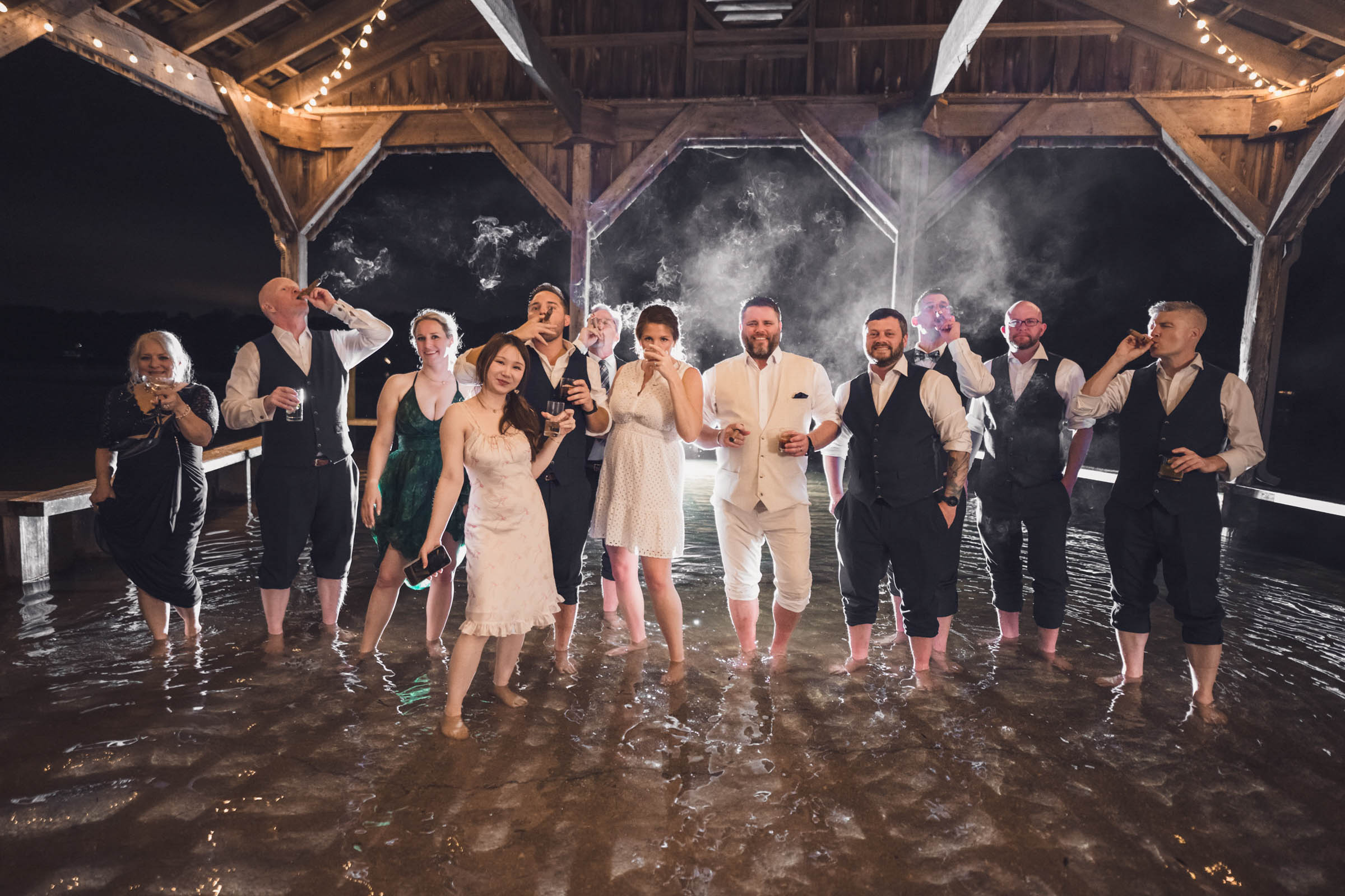 Flooded Cotton Dock Wedding Party Wedding guests standing barefoot in floodwater beneath the Cotton Dock at night during a Boone Hall reception