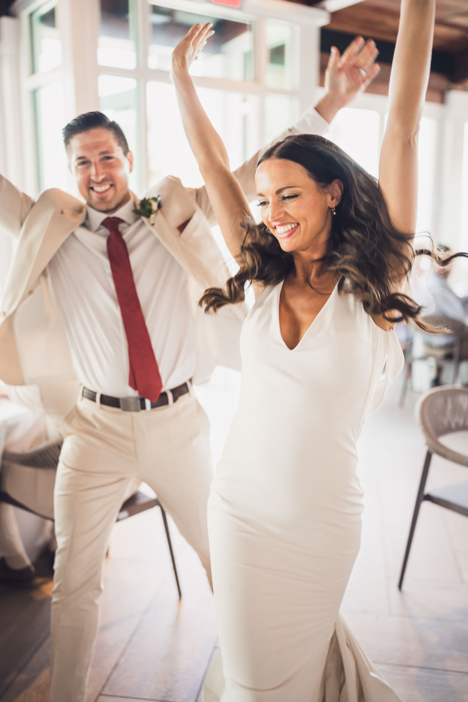 Newlyweds raise their arms and smile as they enter their reception at Charleston Harbor Resort & Marina.