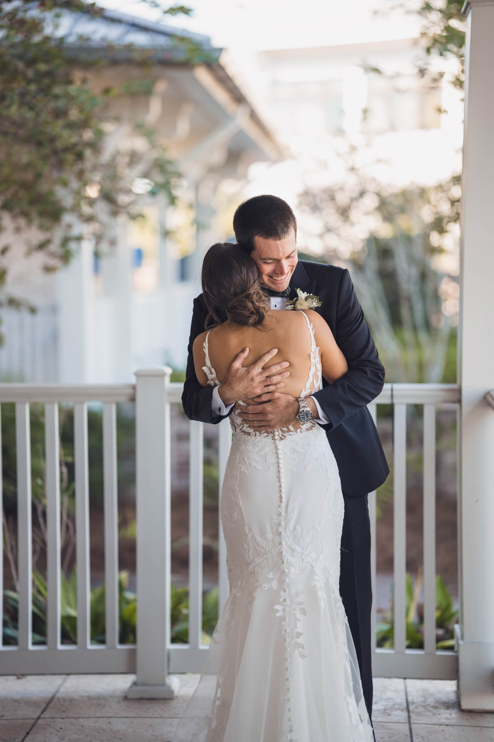 Groom embraces the bride during an emotional first look on the covered porch at Charleston Harbor Resort.