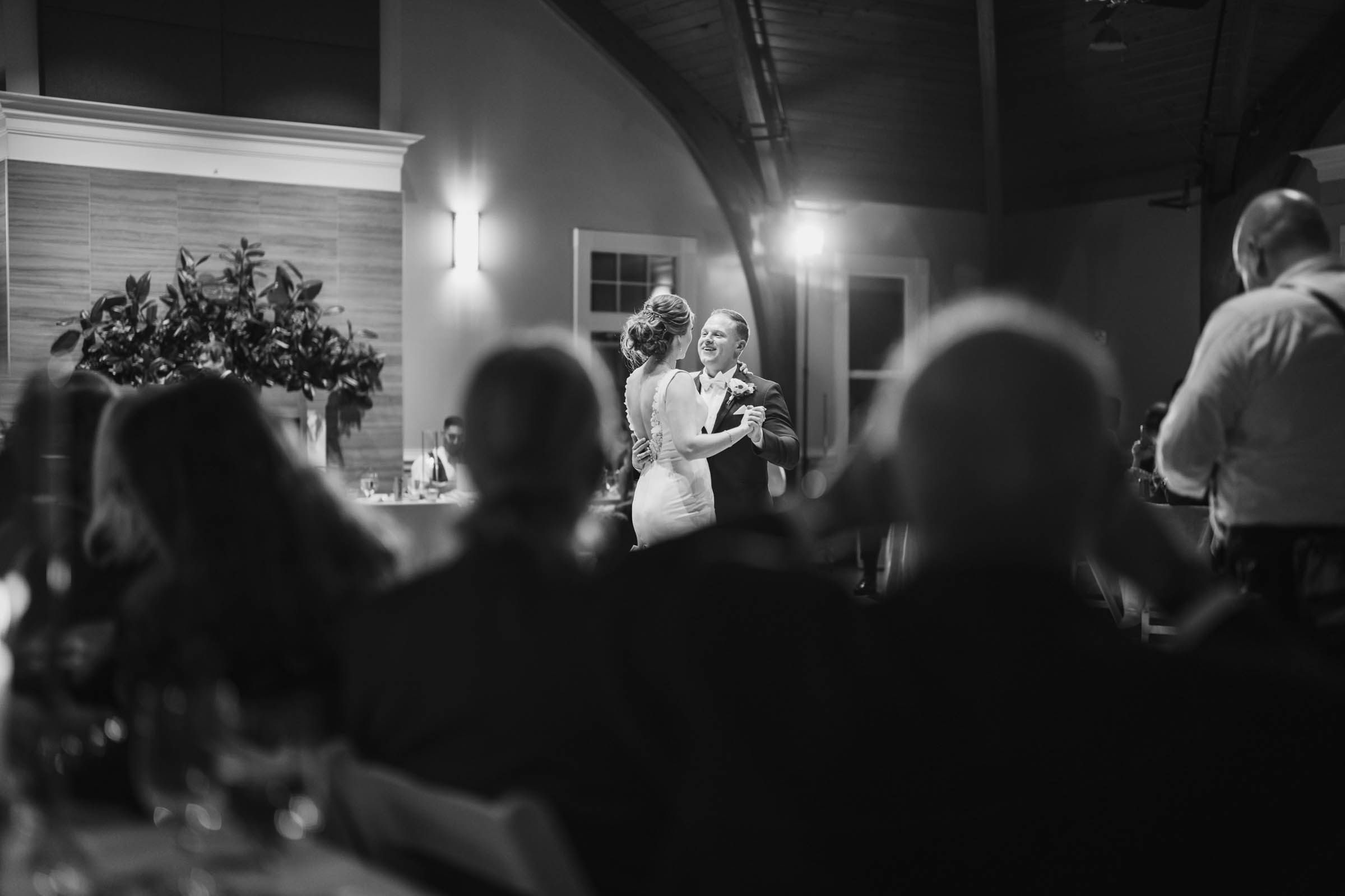 Black and white photo of a bride and groom sharing their first dance inside the Citadel Beach Club reception space.