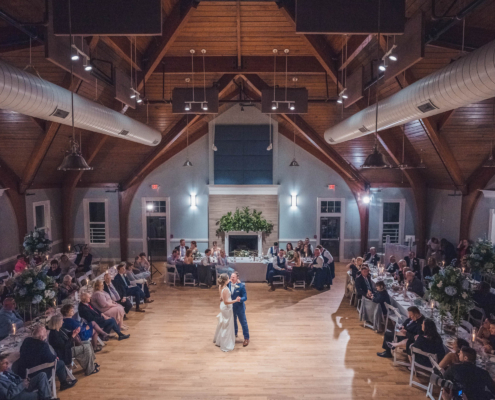 Wide interior view of a wedding reception at Citadel Beach Club showing the high wood ceiling, dance floor, and guests seated around the room.