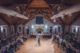 Wide interior view of a wedding reception at Citadel Beach Club showing the high wood ceiling, dance floor, and guests seated around the room.