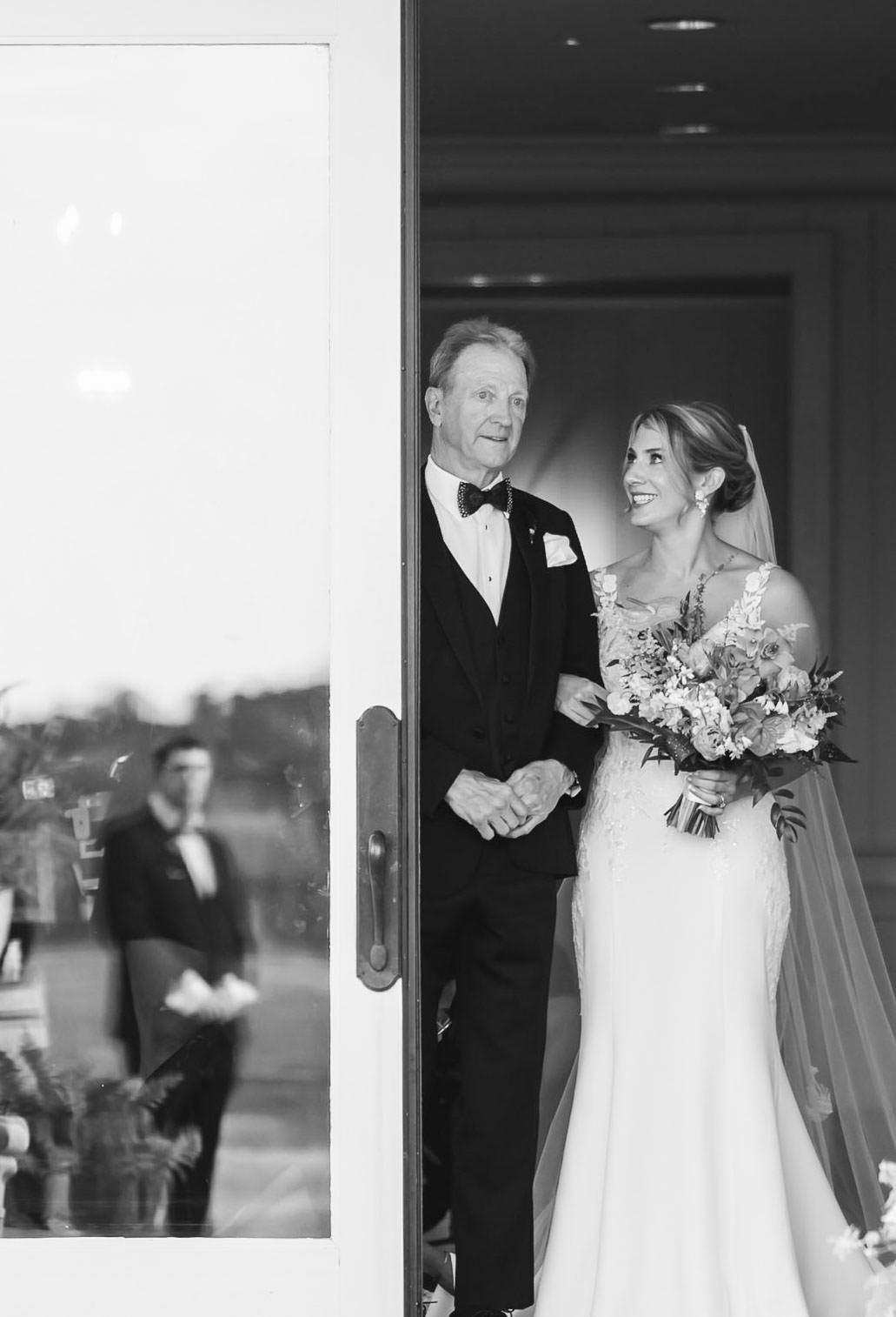 Bride and Father Before the Ceremony Black-and-white photograph of a bride smiling at her father before walking into her Daniel Island Club wedding ceremony.