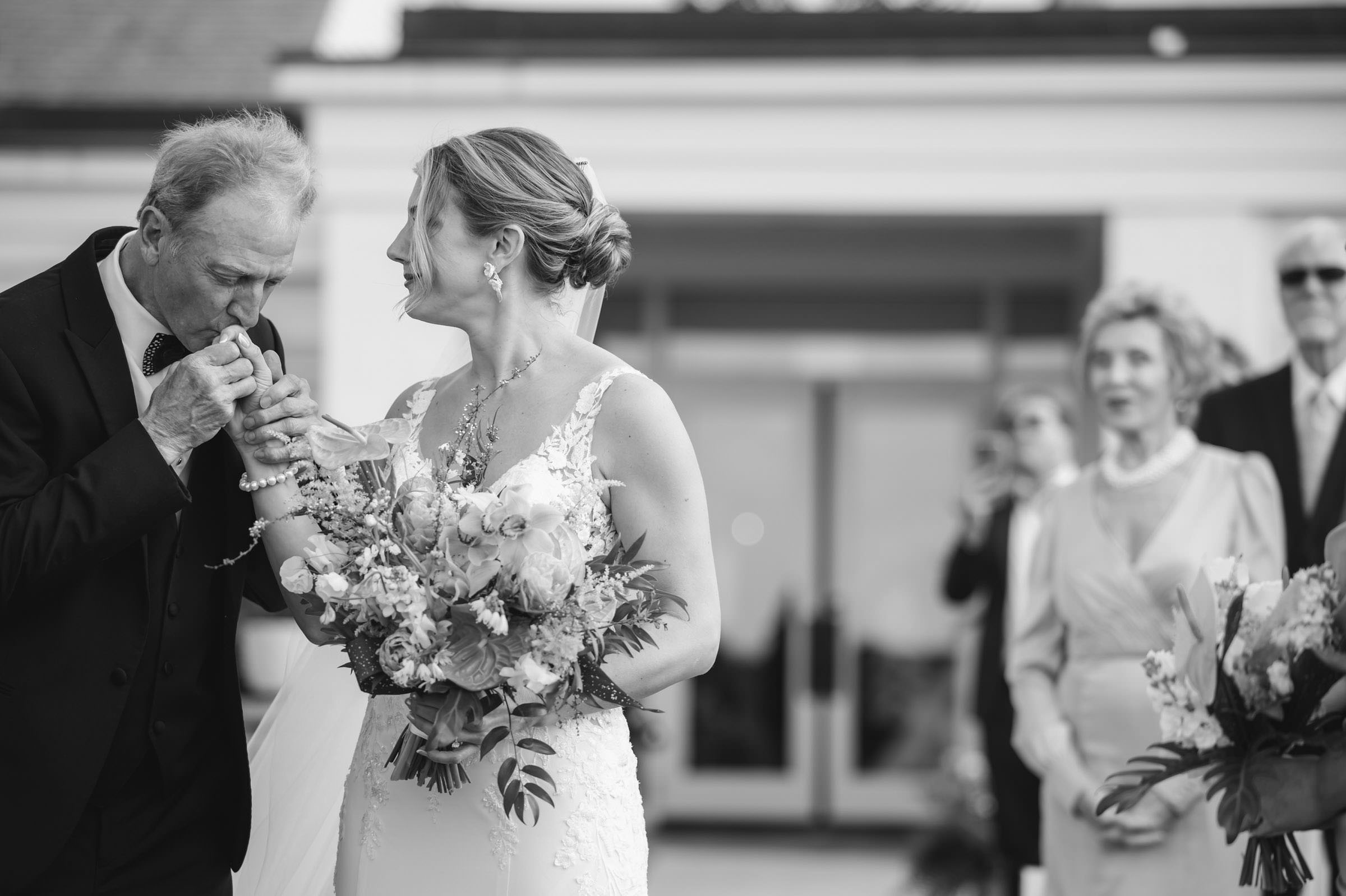 Father and Bride Wedding Moment Black-and-white candid of a father kissing his daughter's hand before her wedding ceremony at Daniel Island Club.