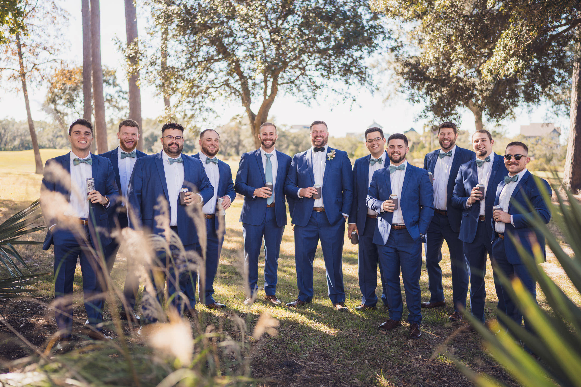 Daniel Island Club Groomsmen Groom and groomsmen in blue suits posing outdoors on the grounds of Daniel Island Club.