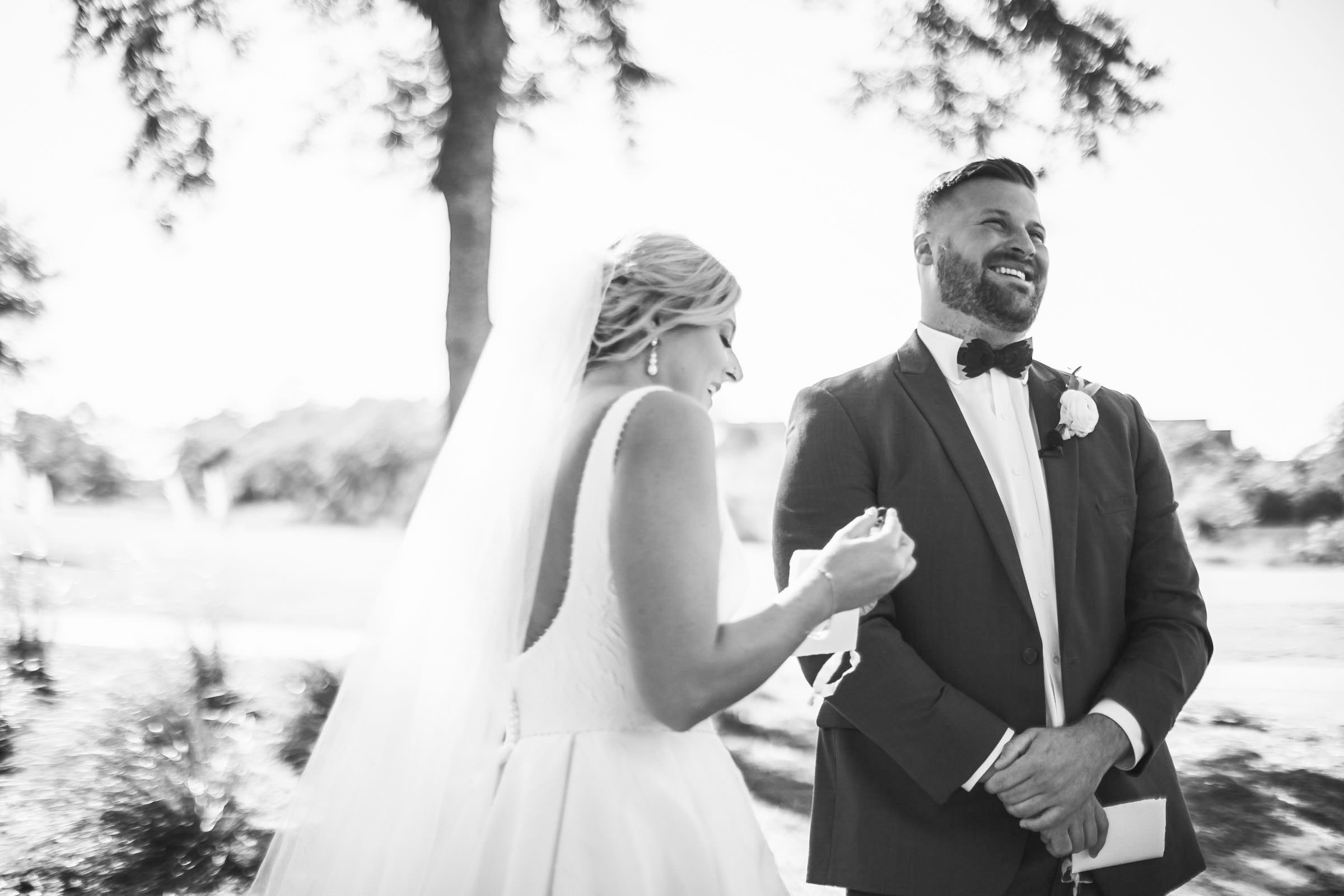 Candid Bride and Groom Wedding Moment Black-and-white candid of a bride and groom laughing together during their wedding day at Daniel Island Club.