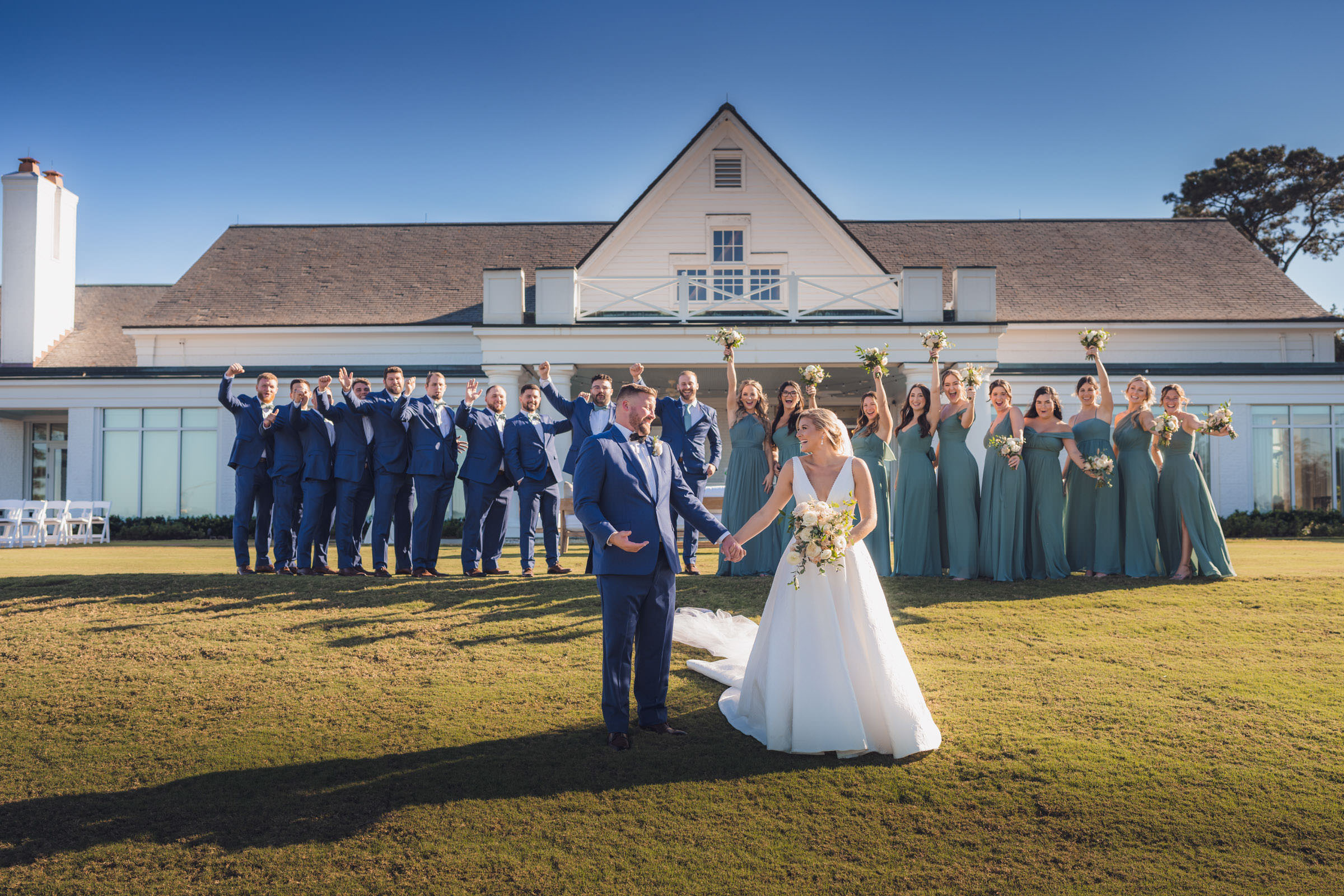 Daniel Island Club Wedding Party Bride and groom holding hands in front of their full wedding party on the lawn at Daniel Island Club.