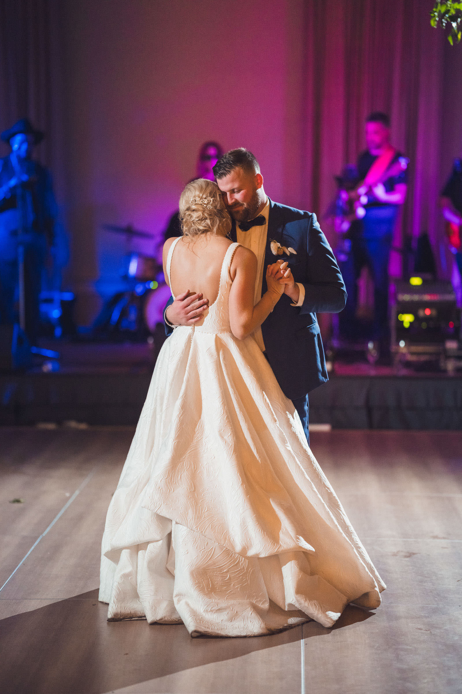 First Dance at Daniel Island Club Bride and groom sharing their first dance during the indoor Daniel Island Club wedding reception with the band behind them.