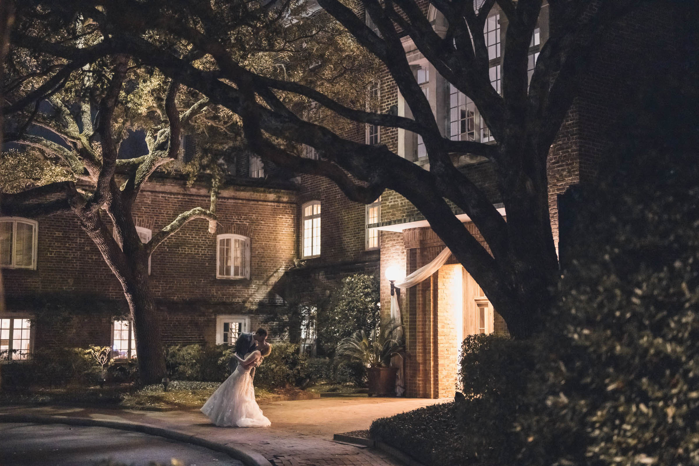 Historic Rice Mill Night Wedding Portrait Bride and groom share a playful nighttime dip beneath sprawling live oaks outside the Historic Rice Mill.