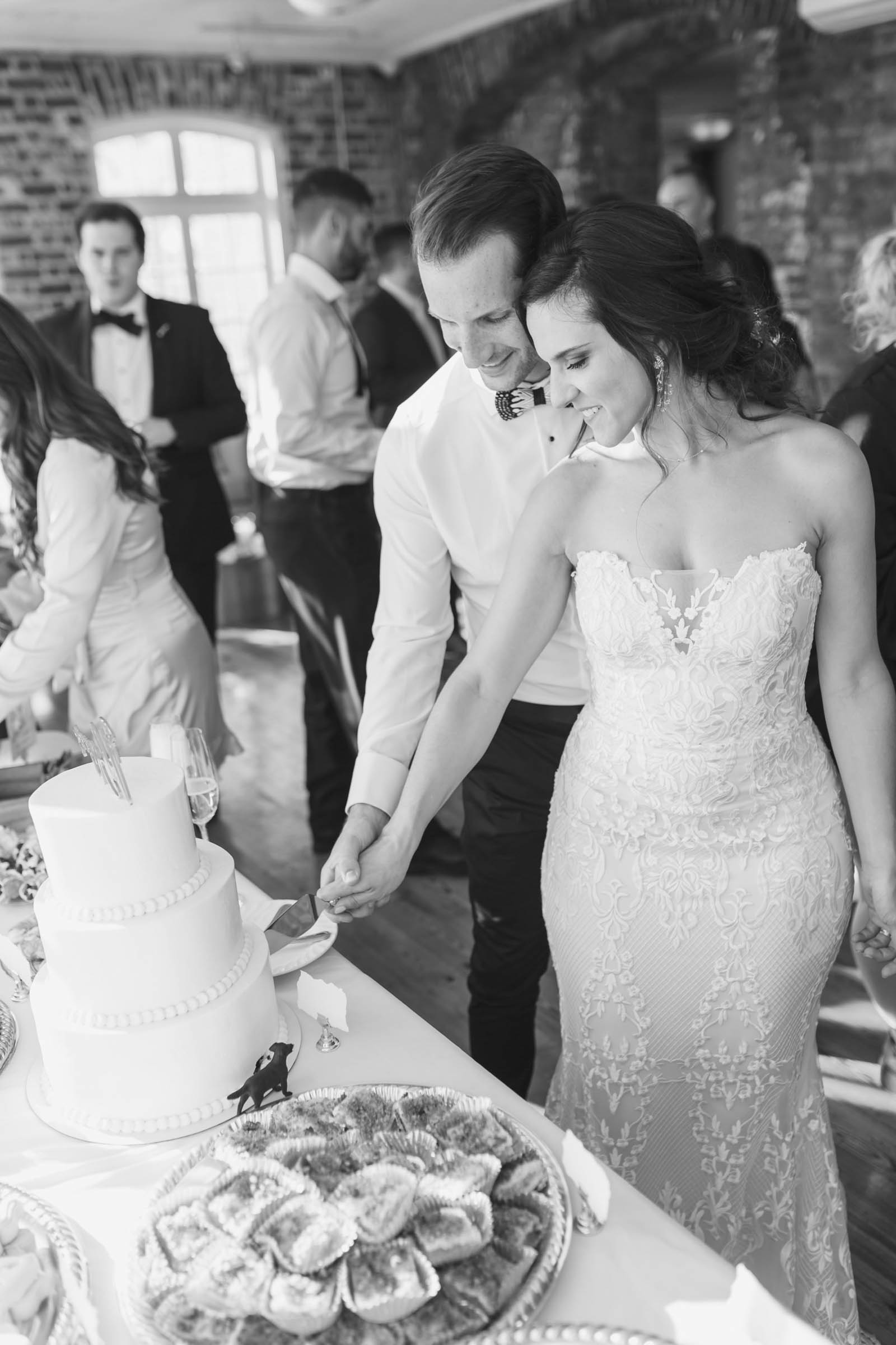 Historic Rice Mill Wedding Cake Cutting Bride and groom cut their wedding cake together during a reception at the Historic Rice Mill in Charleston.