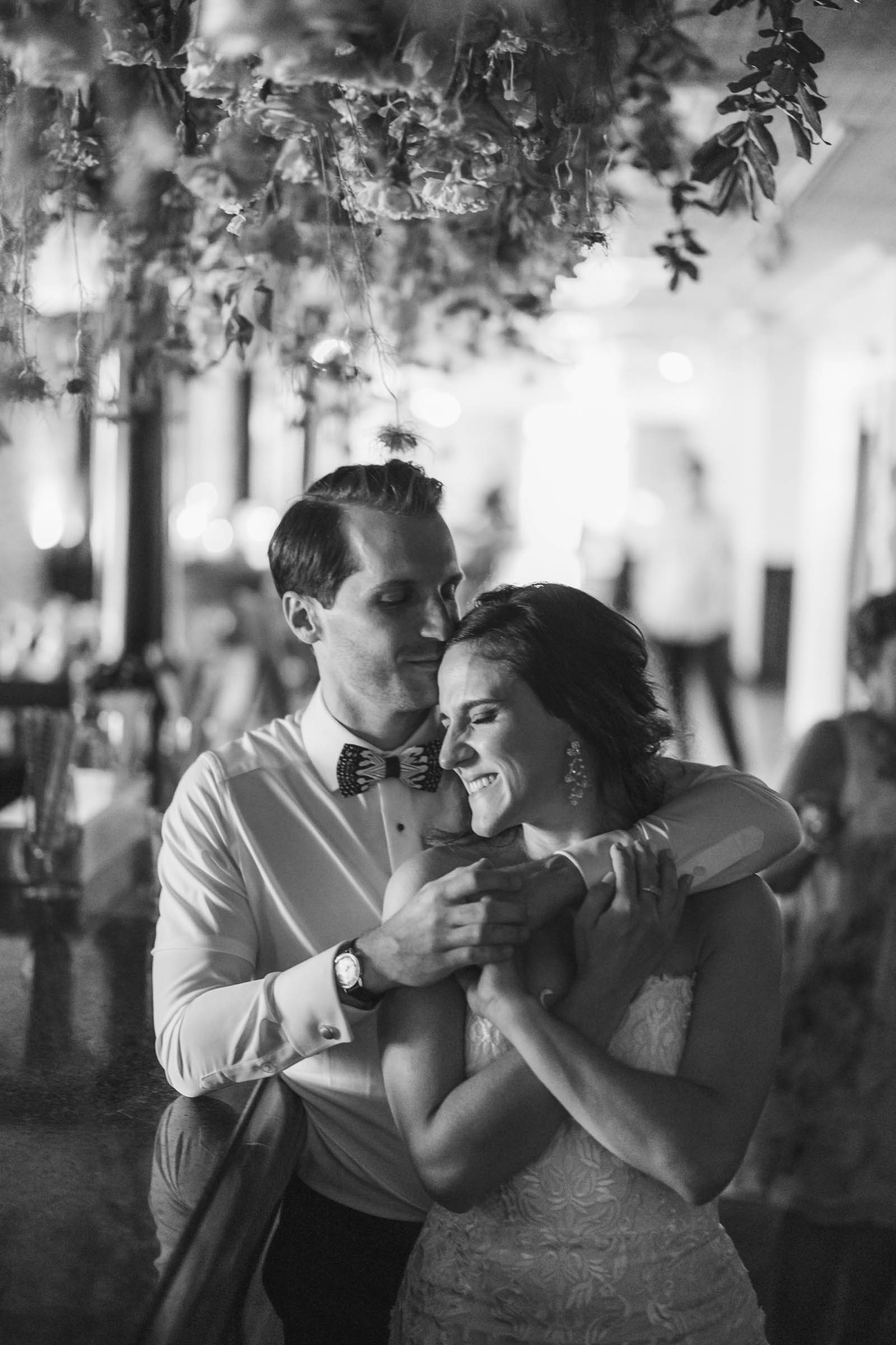 Candid Historic Rice Mill Wedding Portrait Newlyweds hold each other and smile during their wedding reception inside the Historic Rice Mill.