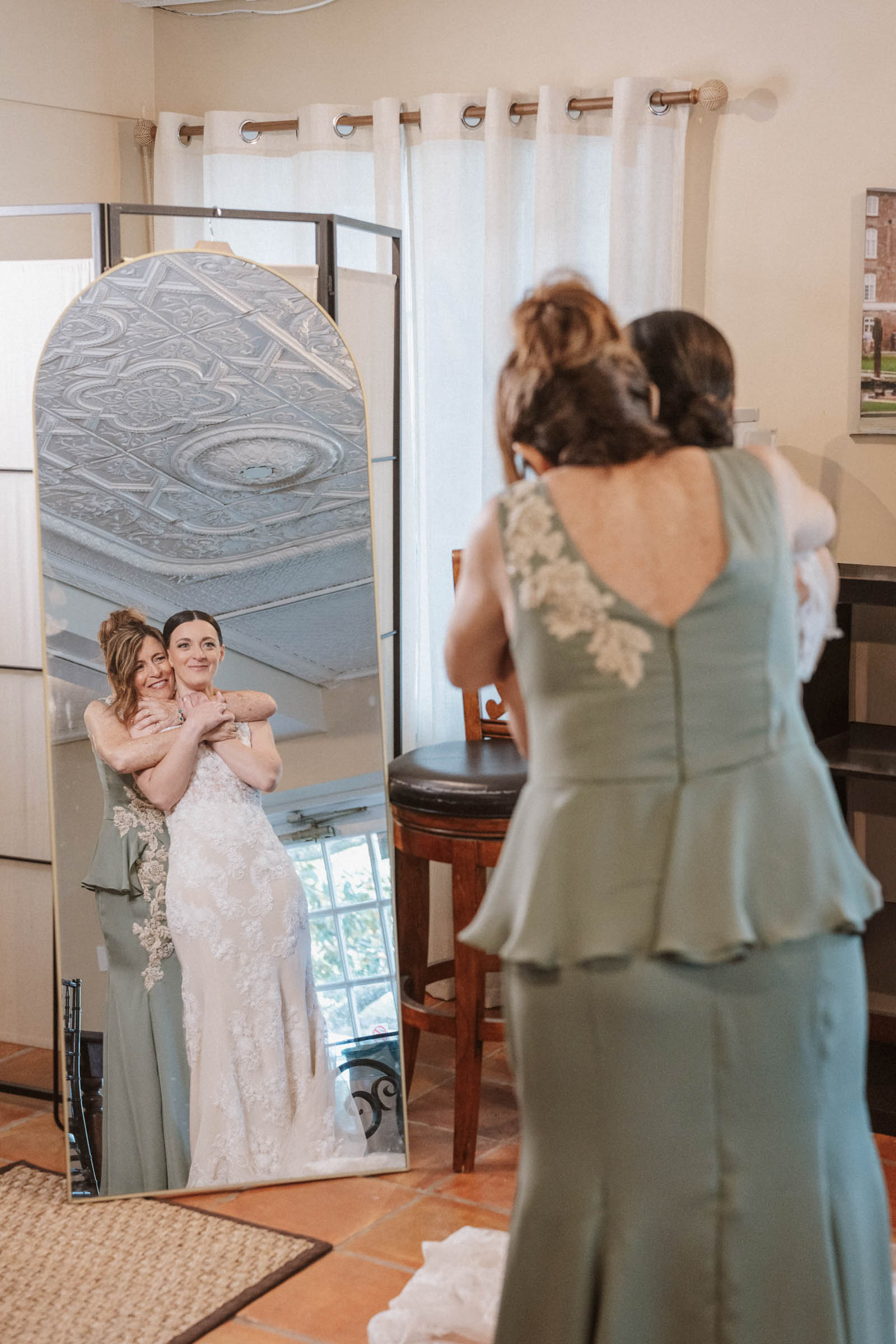 Getting Ready at the Historic Rice Mill Bride and a family member embrace in front of a mirror while getting ready for a Historic Rice Mill wedding.