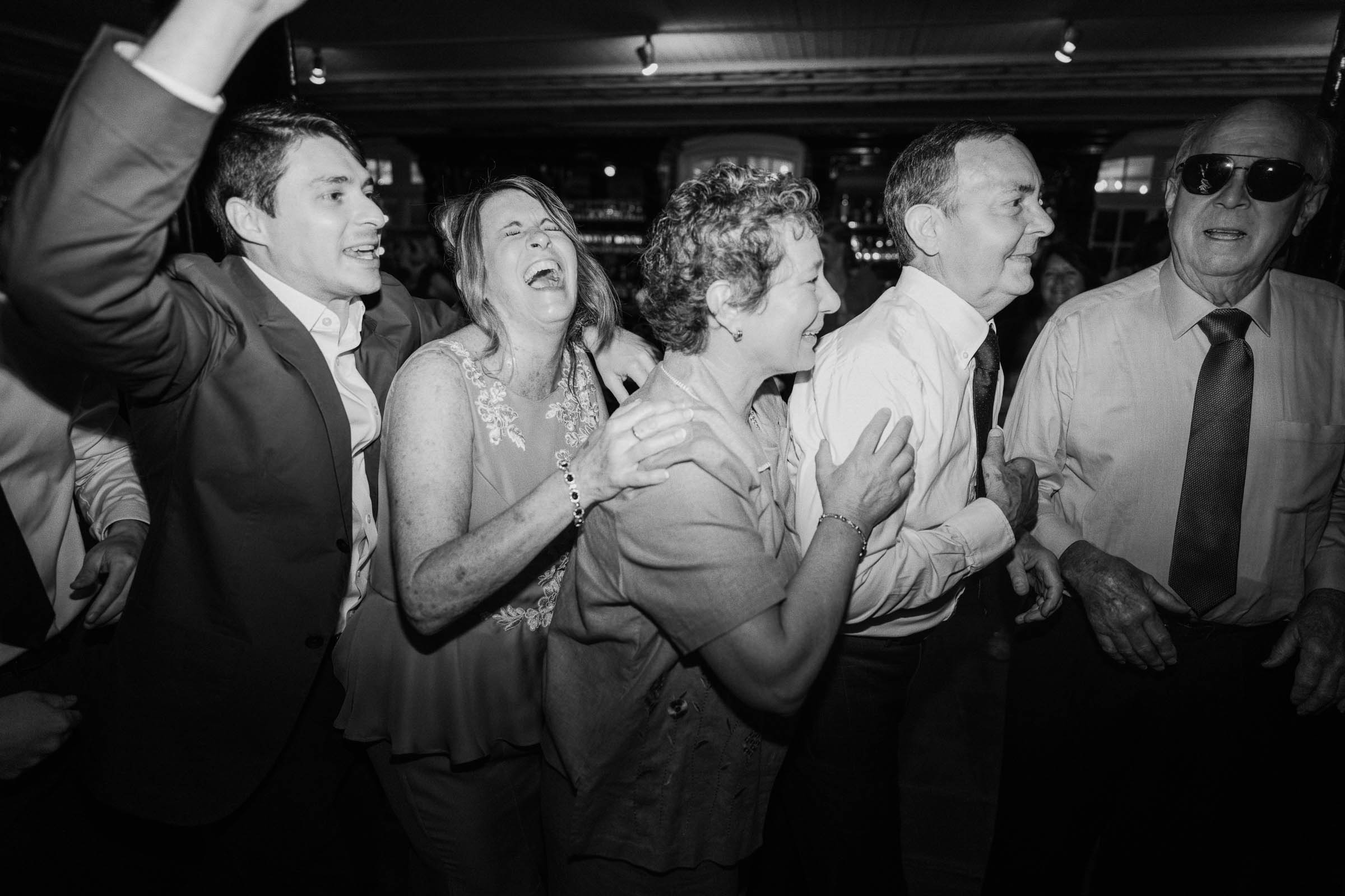 Historic Rice Mill Wedding Reception Candids Wedding guests laugh and dance together during a black-and-white reception at the Historic Rice Mill.