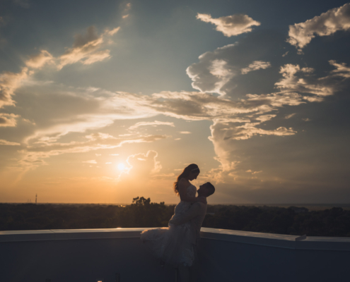 Silhouette of Bride and Groom on Hotel Rooftop at Sunset