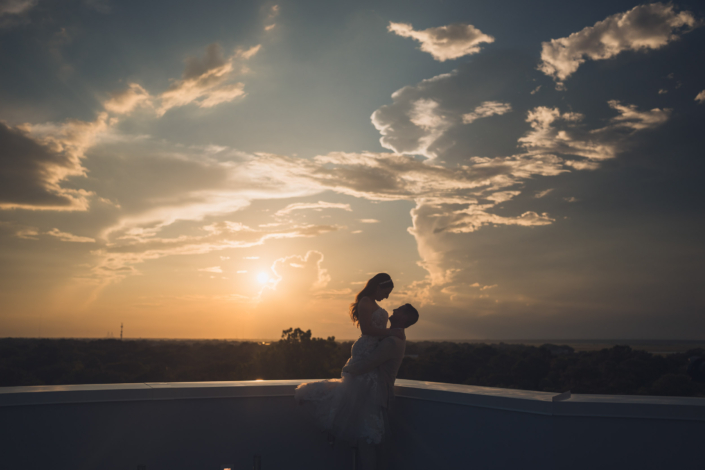 Silhouette of Bride and Groom on Hotel Rooftop at Sunset