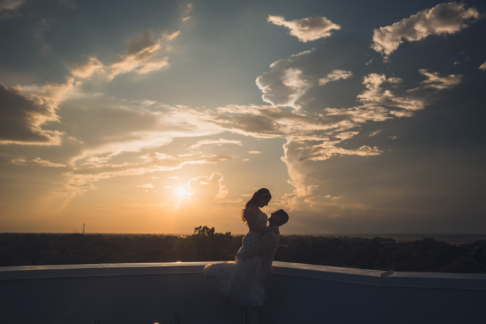 Silhouette of Bride and Groom on Hotel Rooftop at Sunset