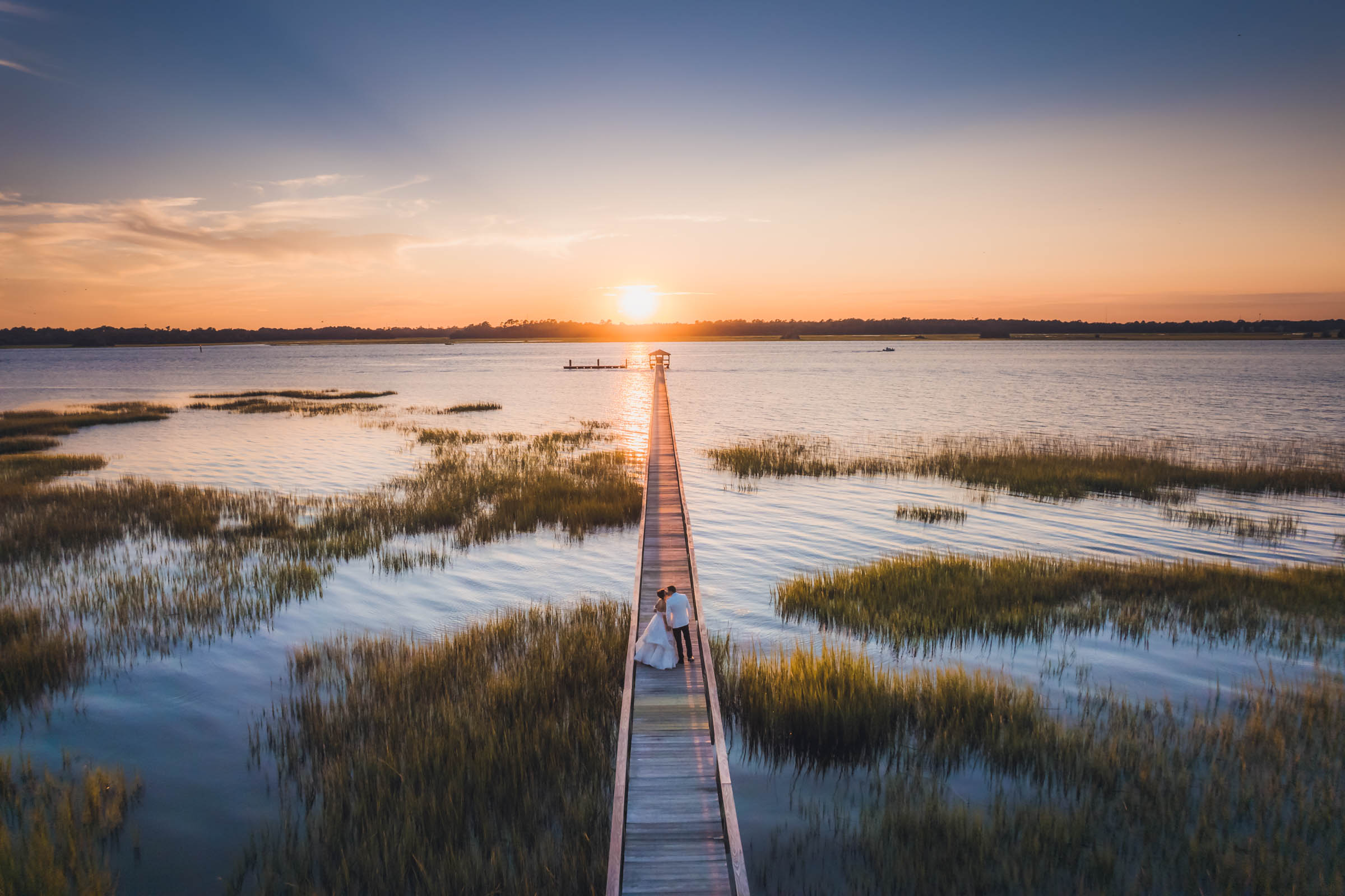 Bride and Groom take a sunset walk on the long dock at Lowndes Grove after their wedding.