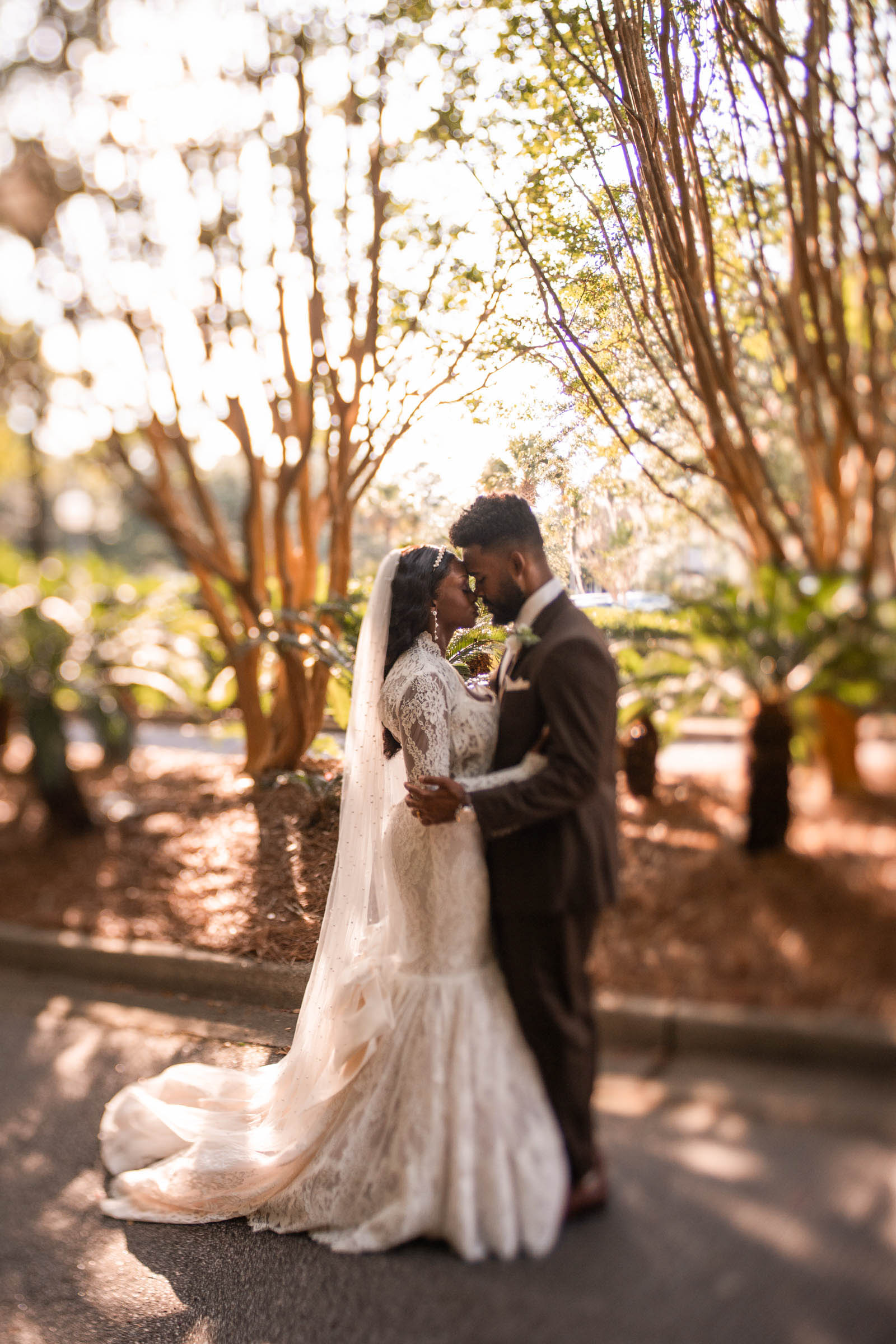 A dreamy tilt-shift image of a couple standing forehead to forehead near the Exchange Mt. Pleasant.