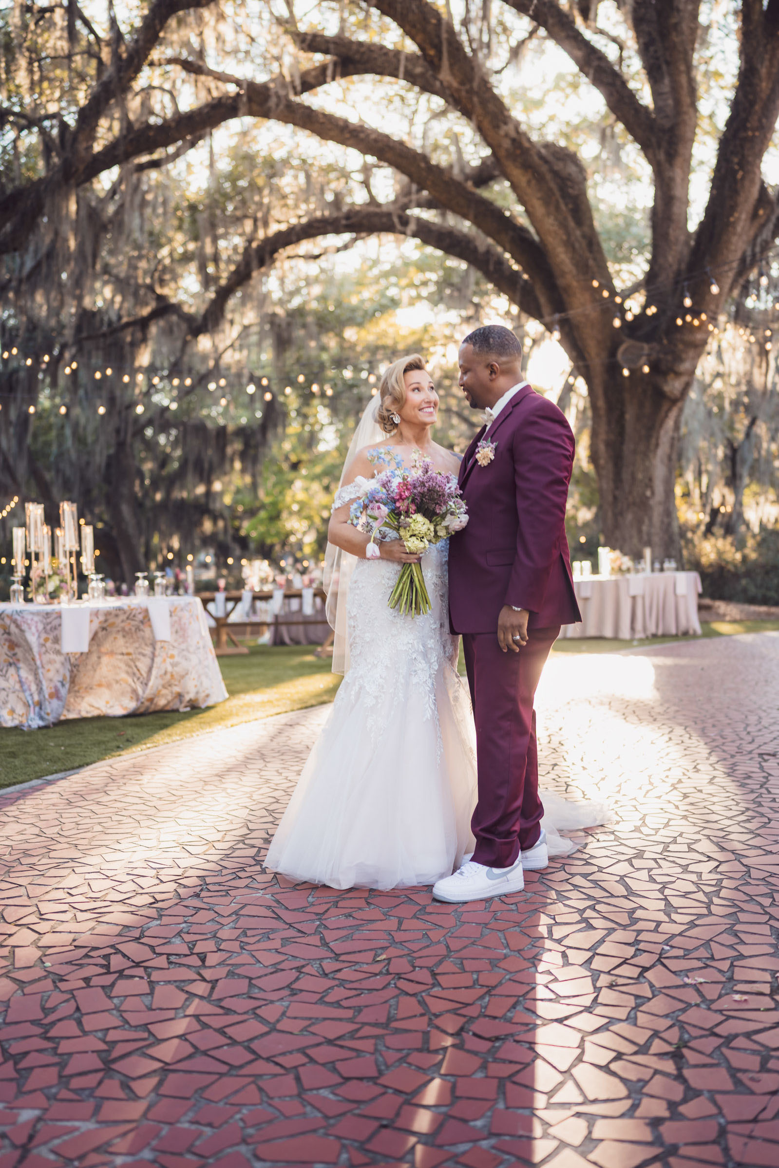 Bride and groom portrait under oak trees on brick path at Admiral’s House Riverfront Park